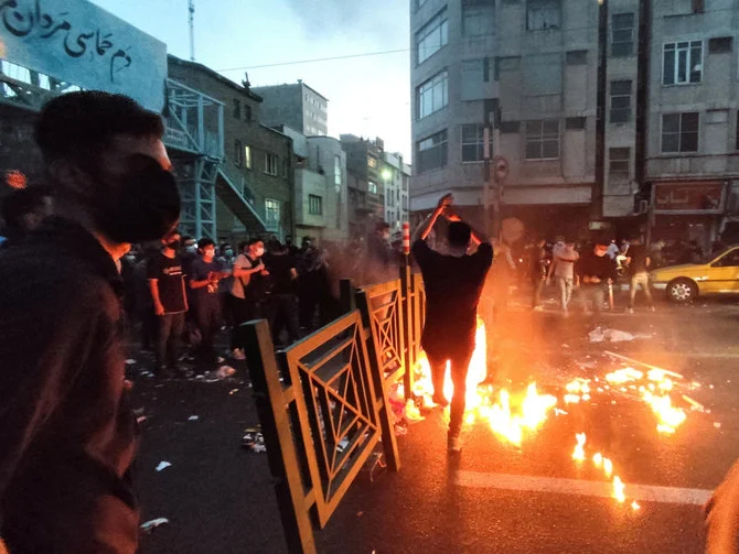 2022 年 9 月 21 日、イランのテヘランで、イスラム共和国の「道徳警察」に逮捕され、その後死亡した女性マフサ・アミニさんの死に対する抗議活動中に人々が放火を行う。(ファイル/ロイター)