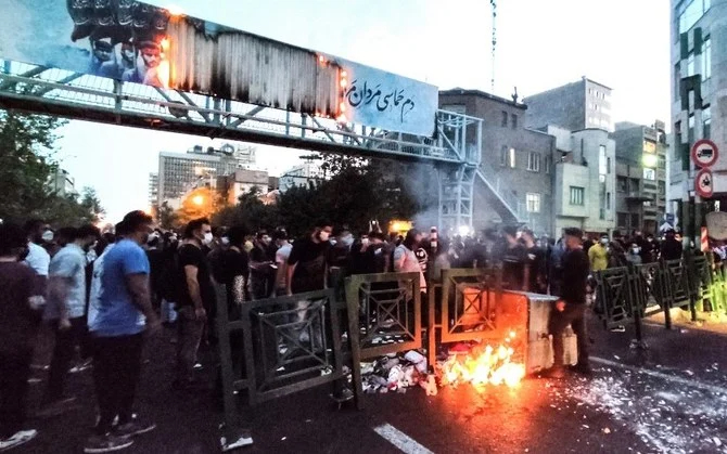 テヘランで行われたマフサ・アミニさんの死に対する抗議デモで、ゴミ箱に火を放つイランのデモ隊（2022年9月21日撮影）。（AFP）