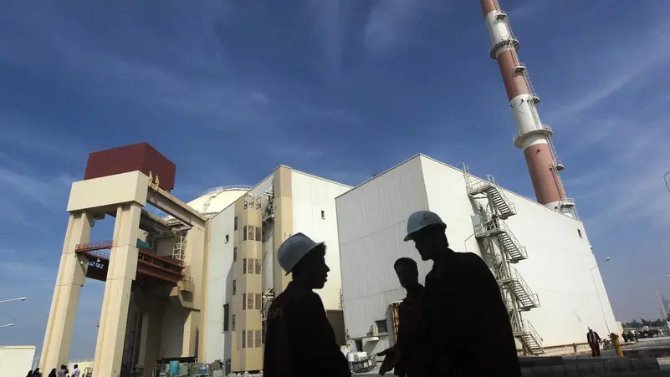 テヘラン南部にあるブシェール原子力発電所の前に立つイラン人労働者。（ロイター/ファイル）