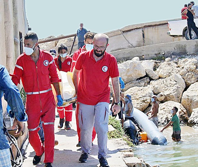 レバノンから不法移民を運ぶ船がシリア沿岸で沈没した後、タルトゥースでシリア赤新月社の職員が犠牲者の遺体を運んでいる。(AFP)