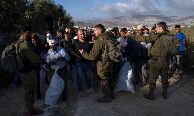 オリーブ収穫のために自分たちの土地に向かっていたパレスチナ人の農民たちに対して保安検査を実施するイスラエル軍部隊。2022年10月18日（火）、ヨルダン川西岸地区のナブルスの東にあるサレム村。（AP）