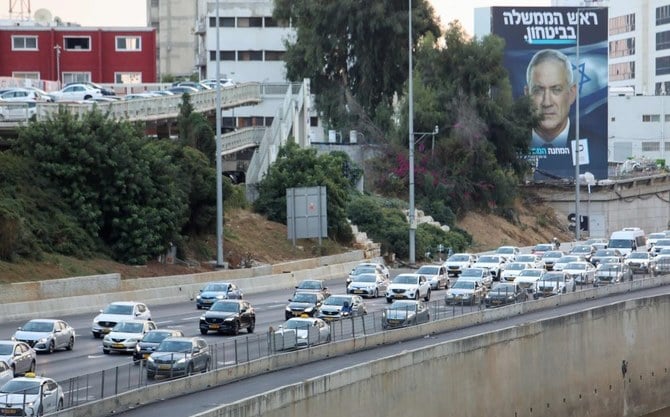 2022年10月23日、沿岸都市テルアビブの高速道路で、イスラエルのベニー・ガンツ国防相が描かれた選挙用看板の前を通過する車。(AFP)