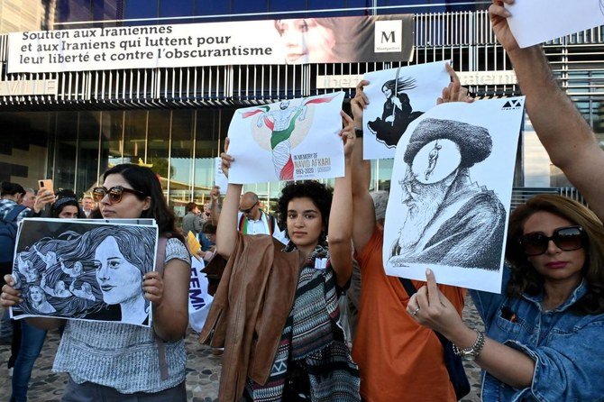 自由のため、蒙昧主義に抗うために自国で戦うイランの人々を支援して、役所の正面に掲げられた横断幕の除幕の際、プラカードを持ってデモを行う女性達。2022年10月3日、フランスのモンペリエにて。（AFP）