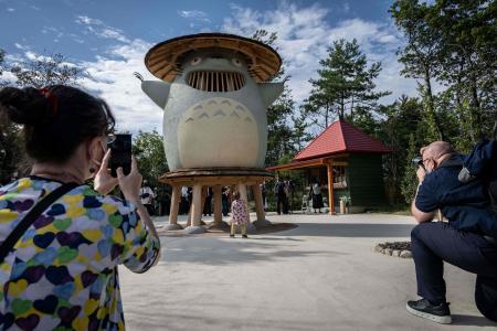 愛知県長久手に新たに出来たジブリパークの報道陣への公開イベント中に、「どんどこ森」でジブリのキャラクター「トトロ」の展示物を撮影する人々。2022年10月12日。（AFP）