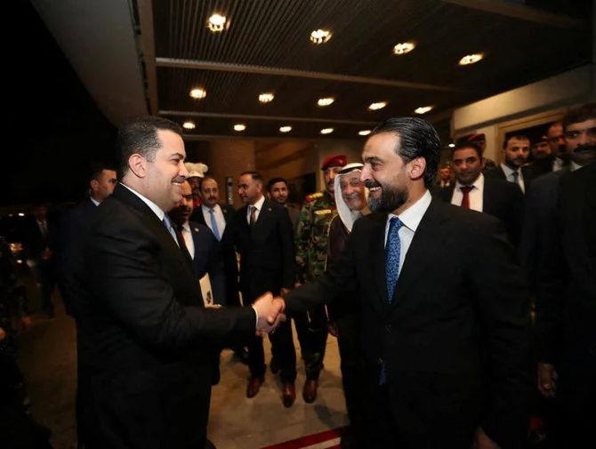 26日にイラクの国会で行われるスダニ内閣に対する投票の前に、イラク議会議長モハメド・アル・ハルブーシ氏と握手するイラクの次期首相に指名されたムハンマド・シア​​・アル・スダニ氏（ロイター）