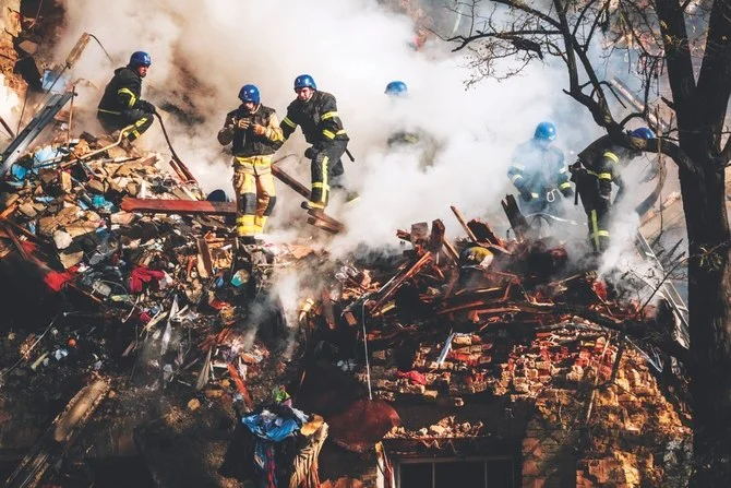 17日、ドローン攻撃で破壊されたキーウの建物の残骸の中で活動する消防士。（AFP）