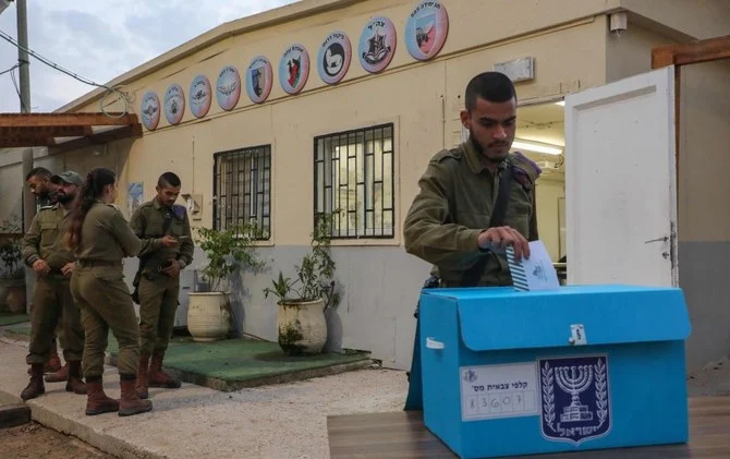 2022年10月31日、ガザ地区との国境に近いイスラエル南部のケレム・シャロム陸軍基地で、総選挙の投票日より1日早く期日前投票するイスラエル兵。（AFP）