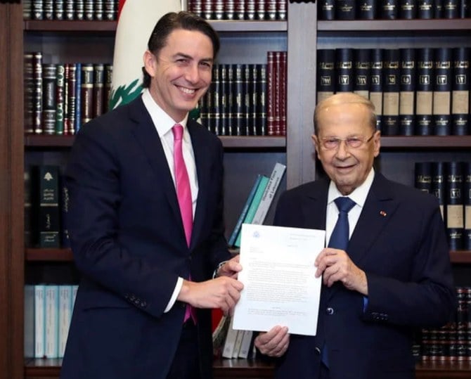 アモス・ホッホスタイン米国エネルギー問題担当特使から、レバノン・イスラエル間の海上国境設定の協定書を受け取るミシェル・アウン前レバノン大統領、2022年10月27日ベイルートにて(AP/File)