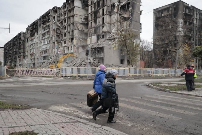 ドネツクの損傷したアパートのそばを通り過ぎる女性たち。ドネツクでは、6月に外国人3人に死刑判決を言い渡した判事がウクライナ人に銃で撃たれ重傷を負った。（AP）