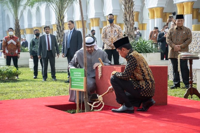 モスクの中庭の外にインドネシアを象徴する木である沙羅双樹を植えるUAEのムハンマド・ビン・ザーイド大統領とインドネシアのジョコ・ウィドド大統領。（WAM）