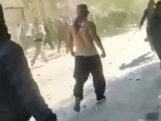 クルド系都市ジャヴァンルドの町中で激しい銃撃が続くなか、石を投げて前進する抗議者たち。(AFP)