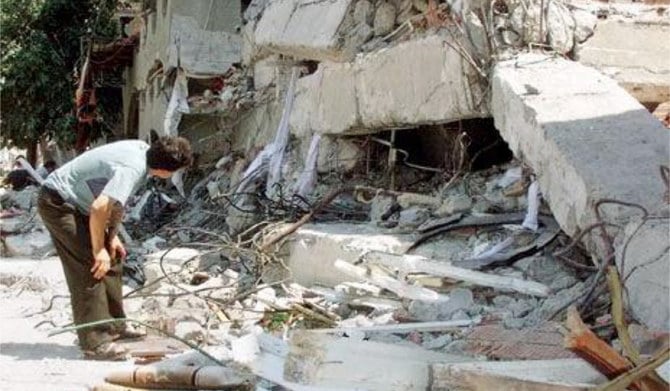 1999年8月19日、イスタンブールのサカリヤ地域で地震によって倒壊した建物の残骸を調査する男性。（AFP）