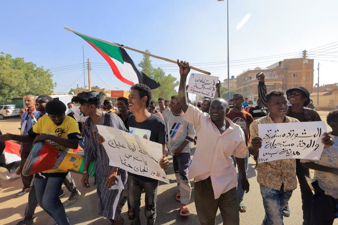 11月23日、ハルツームで最新のクーデターで生じた軍政に抗議して行進するデモ参加者たち。（ロイター）