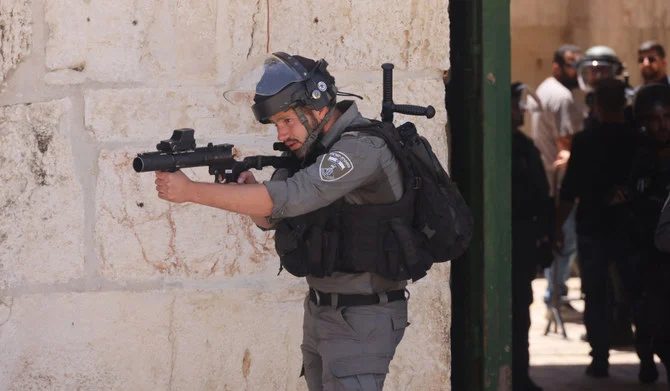 エルサレムでのパレスチナ人による抗議デモ中、催涙弾で狙いを定めるイスラエル治安部隊の隊員。（AFP）