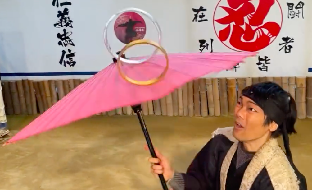 忍者知之介、回る傘の上で金属製の輪のバランスを取り、W杯の勝敗を予想。(スクリーンショット/Twitter/@TvAshura)