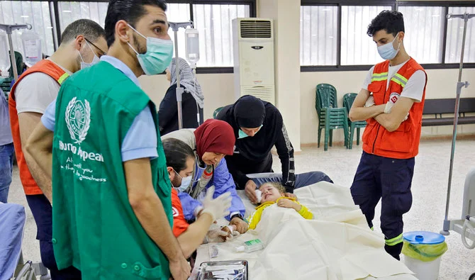 野戦病院で幼いコレラ患者を看護する医療スタッフ。(AFP/File)