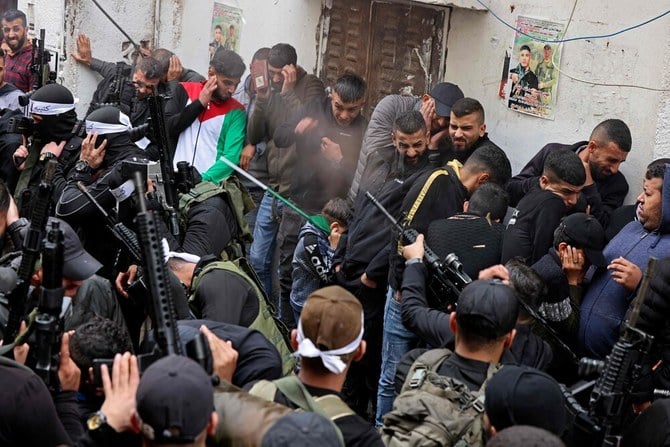 9日、ヨルダン川西岸地区ナブルスの近くにあるバラタで、イスラエルの急襲中に受けた銃弾による傷が原因で死亡した10代のパレスチナ人、マフディ・ハシャシュさんの葬儀が執り行われているときに、武装組織バラタ旅団のメンバーが空に向けて発砲し、弔問客が反応している。（AFP）