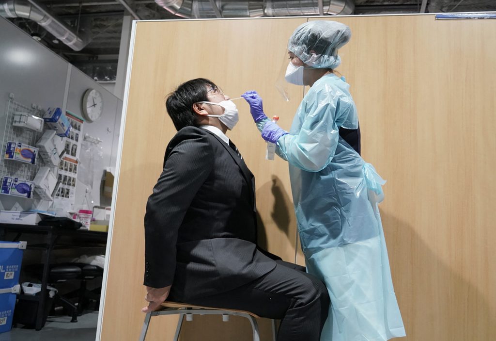 成田空港の検査センターで、新型コロナウイルスの検査を行う医療スタッフ。(AFP通信)