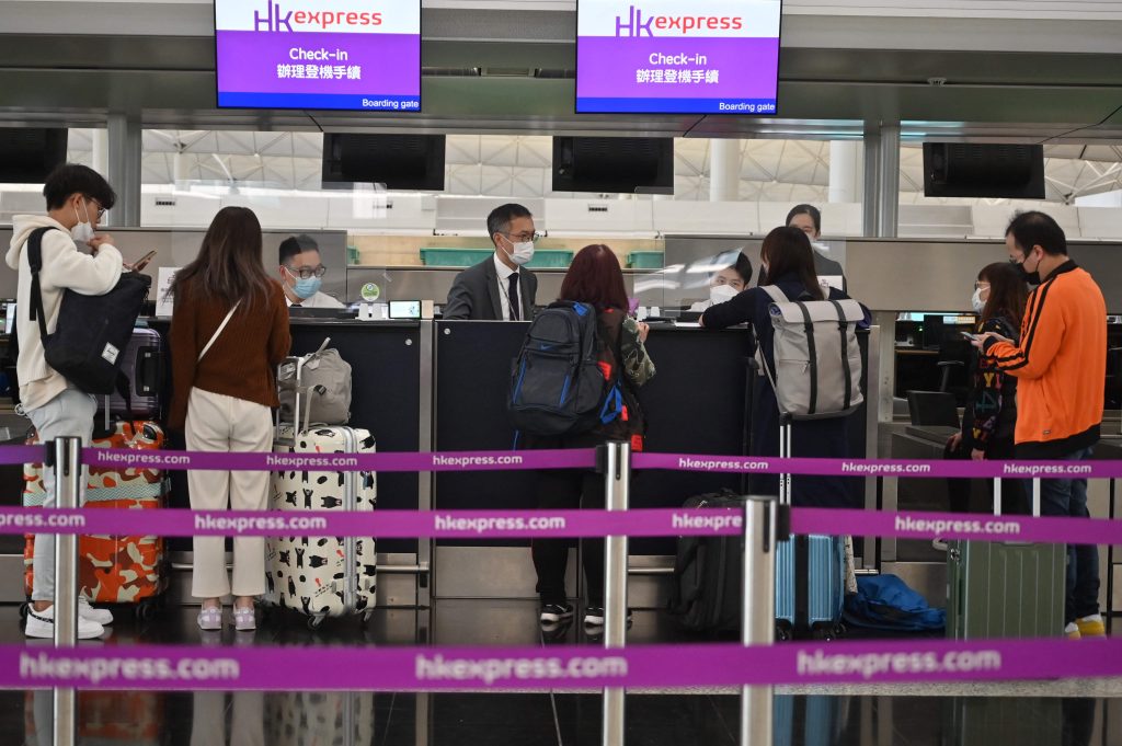 香港国際空港のHKエクスプレスカウンターでチェックインする乗客たち、2022年12月28日。(AFP)