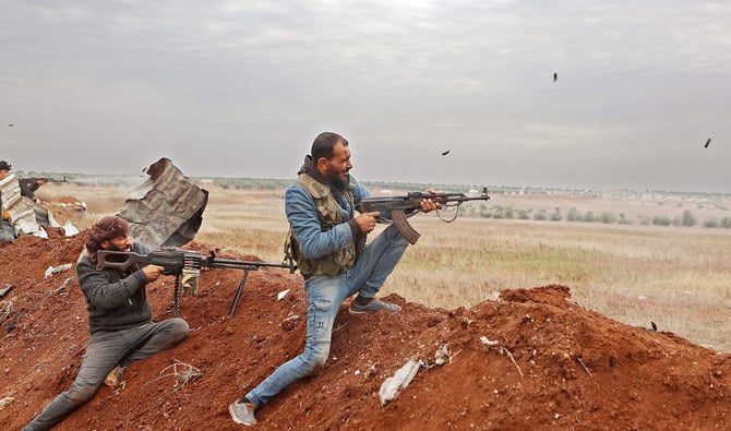トルコの支援を受けたシリア国軍の戦闘員が、アレッポ県北部の反体制派が支配するアザーズ近郊の陣地と、シリア政権部隊が支配する地域の前線に向けて銃撃を行う。（AFP通信）