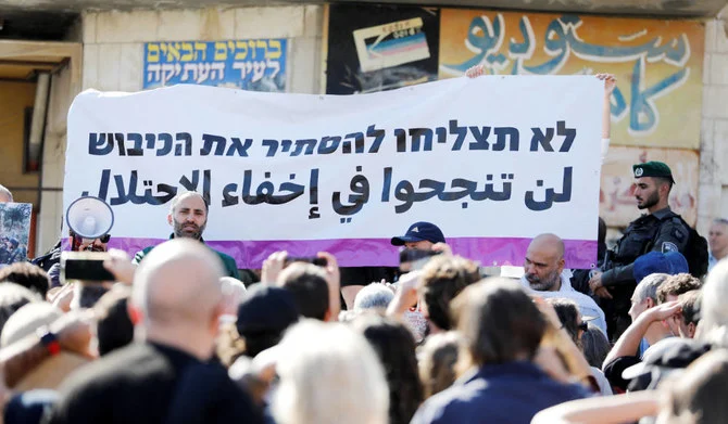 イスラエル占領下にあるヨルダン川西岸地区のヘブロンで団体「ブレーキング・ザ・サイレンス」が企画したツアーにイスラエル人活動家が参加する中、掲げられる横断幕。「占領を隠し