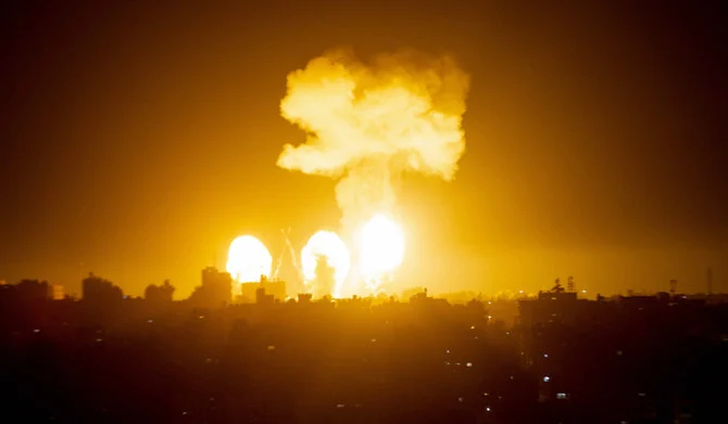 イスラエルの爆撃機による空爆を受けて建物の上に炎と煙が上がる様子。2022年12月4日、ガザ地区南部。（AFP）