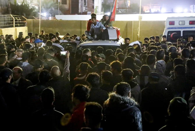 イラクのナシリヤで執り行われた葬儀で、会葬者が、反政府デモ中に殺害されたデモ参加者の棺を運んでいる。（12月7日撮影）（ロイター）