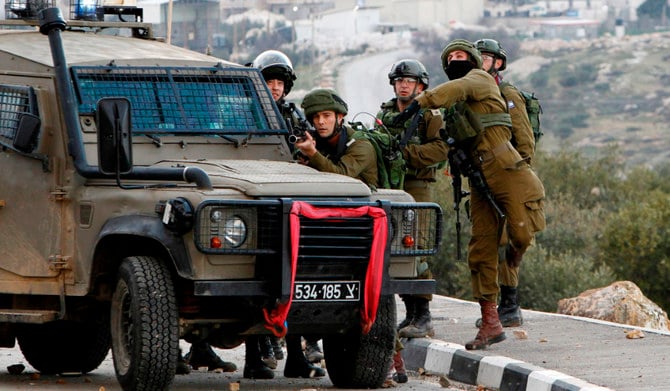 ベツレヘムの南西、ヨルダン川西岸地区の村トゥクアでパレスチナ人デモ隊と衝突するイスラエル軍兵士。（AFP）