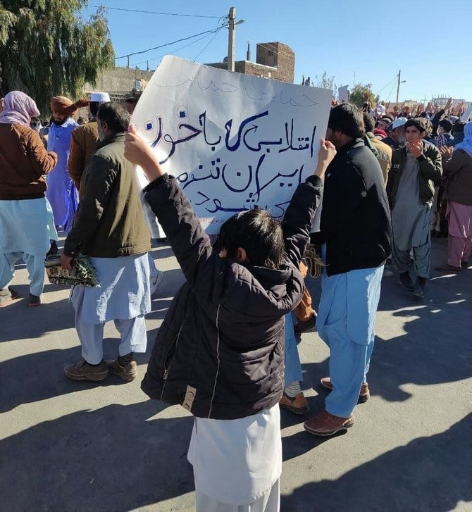 デモに参加している子供が、「血を流して、より強くなる革命」と書かれた紙を掲げている。（ツイッター/@Mojahedineng）