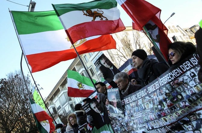 フランクフルト・アム・マインのイラン領事館前で太陽と獅子をあしらった旗（革命前のイラン国旗）を振るデモ参加者。2022年12月16日(AFP)