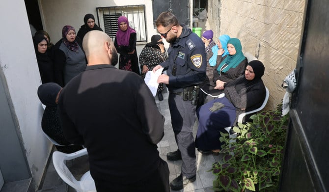 2022年12月23日、テルアビブの東にある、アラブ系イスラエル人が住むカフル・カシムで、深夜に車で体当たりする事件があったという報告があった後、イスラエル警察が住民のところに出向き、話をしている。（AFP）