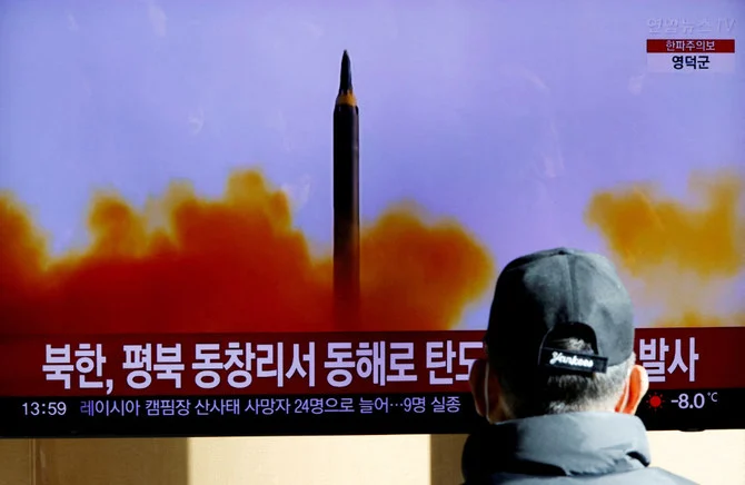 北朝鮮が東側へ弾道ミサイルを発射したと報じるテレビ映像を見る男性（2022年12月18日。ロイター）。