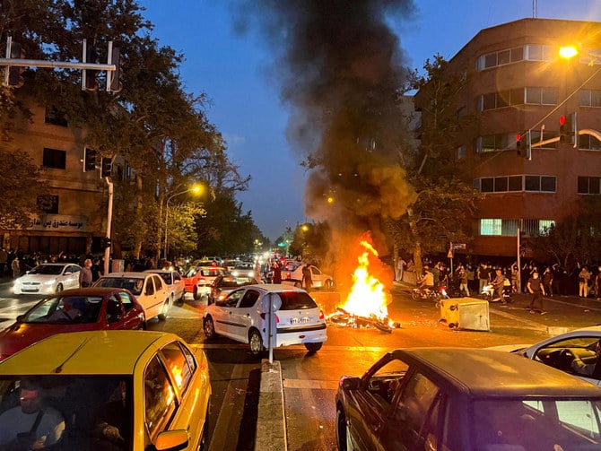 2022年9月19日にイランのテヘランで、イスラム共和国の「風紀警察」に逮捕されたのち亡くなったマフサ・アミニさんの死に対する抗議活動で警察のバイクが燃える。（ロイター/West Asia News Agency）