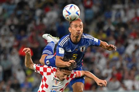 2022年サッカー・ワールドカップ（W杯）決勝トーナメント1回戦で、クロアチア代表のMFルカ・モドリッチとボールを奪い合う日本代表のDF長友佑都（上）。（AFP）