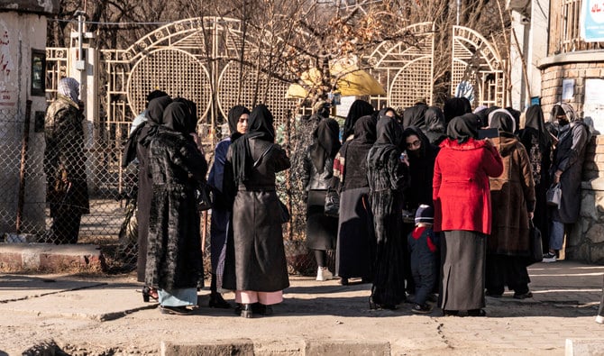 カブールの大学にて、タリバンの警備員に止められるアフガニスタンの女子大学生。（AFP）