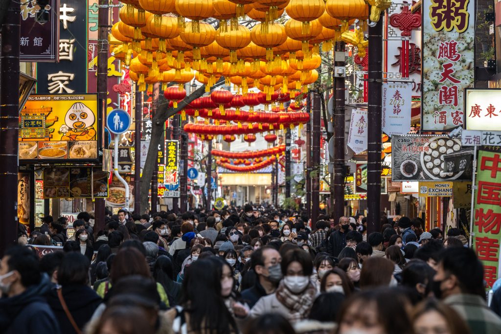 東京の南に位置する神奈川県横浜市の中華街で通りを歩く人々。2023年1月7日撮影。（AFP）