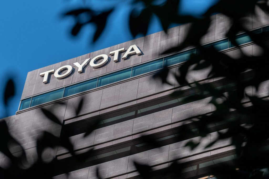 この資料写真には、東京の本社の上に掲げられたトヨタ自動車のロゴが写っている。（資料／AFP）