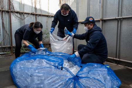 東京都足立区の白井エコセンターで、プラスチック汚染問題を訴える革新的なバレエ公演、「プラスチック」の衣装やセットに使用するため、ペットボトルを分別する人たち。（2022年11月12日撮影　AFP)