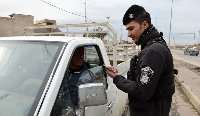 モスルの検問所で運転手のIDを確認するイラクの警察官。（AFP）