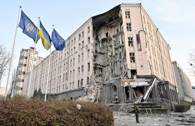 ロシアによる攻撃で一部損壊したホテルの前に立つ軍人。2022年12月31日、ウクライナの首都キーウ中心部。（AFP）