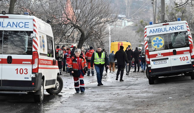 ロシアによる攻撃で一部損壊した家屋の傍で働く医療関係者と警察官。2022年12月31日、ウクライナの首都キーウ。（AFP）