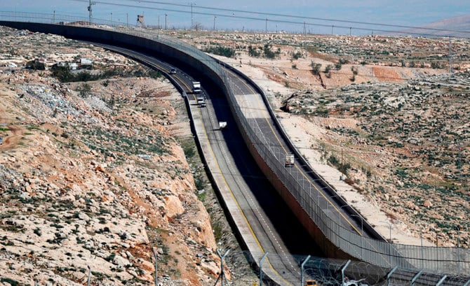 2019年1月10日、パレスチナ人用(左)とイスラエル人と定住者専用の側(右)に壁で隔てられた新しいイスラエルの道路を車両が走る。(AFP通信)