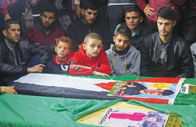 パレスチナ人移住者4人の葬儀にて、棺の周りに集まる参列者たち。ガザ地区南部ラファフのモスク。（AFPファイル写真）