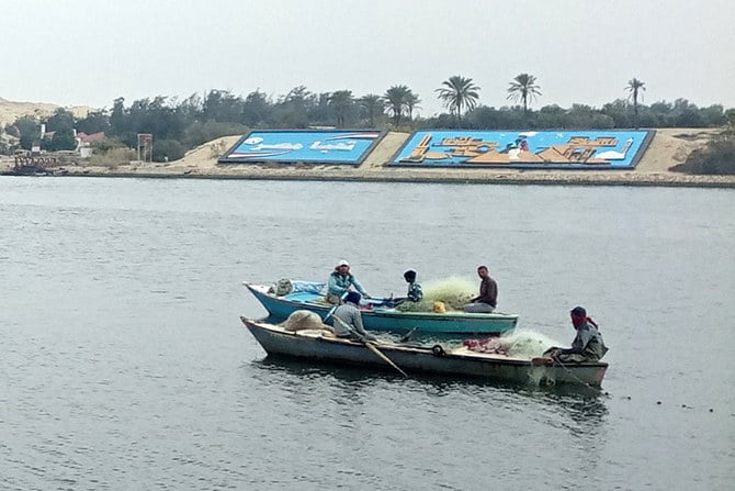 2023年1月9日、エジプト東部イスマイリア近郊のスエズ運河をボートで航行する漁師たち。（AFP）