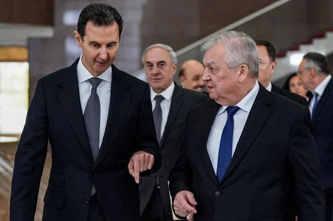 ロシアのアレクサンドル・ラブレンチエフ・シリア問題担当大統領特使(右)とその随行代表団を迎えるシリアのバッシャール・アサド大統領(左)。シリアの首都ダマスカス。(AFP)