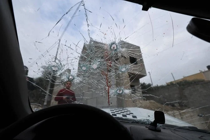 ヨルダン川西岸地区の町ジェニンに近いジャバでイスラエル軍により車中のパレスチナ人2人が殺害されたと伝えられた。その車の弾痕だらけのフロントガラスを少年が見つめている。(AFP)