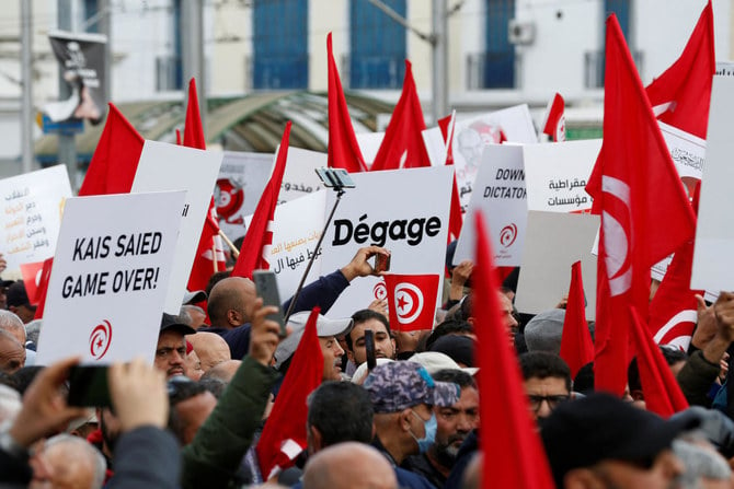 2023年1月14日、2011年に起きた蜂起の記念日にチュニスで、チュニジア大統領カイス・サイード氏に対する抗議行動中にプラカードを掲げるデモ参加者。（ロイター）