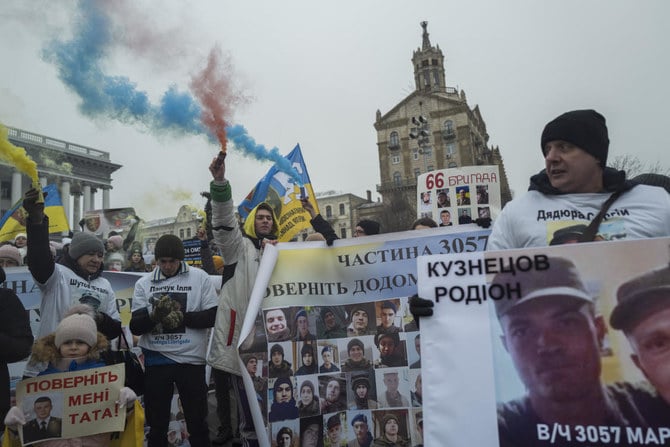 2023年1月14日、行方不明の兵士たちの写真を手に持ち、キーウ市内でデモをするウクライナ人。(AP)