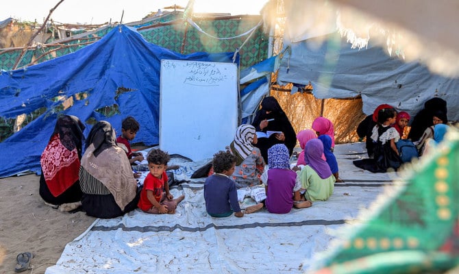 イエメン西部のホデイダ県コーハ地区の避難民キャンプにて、テントの中で授業を受ける子どもたち。（AFP/ファイル）