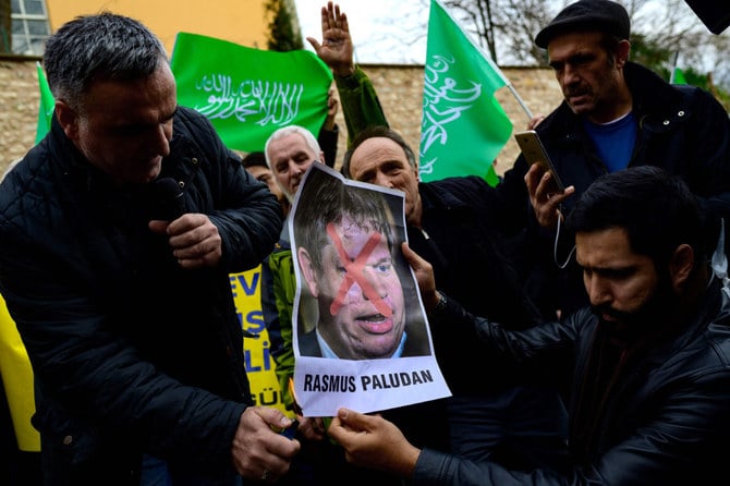 極右のラスムス・パルダン氏がストックホルムのトルコ大使館近くでコーランを燃やしたのを受け、トルコ・イスタンブールのスウェーデン総領事館の前で同氏の写真を燃やすデモ隊（2023年1月22日）。（AFP）